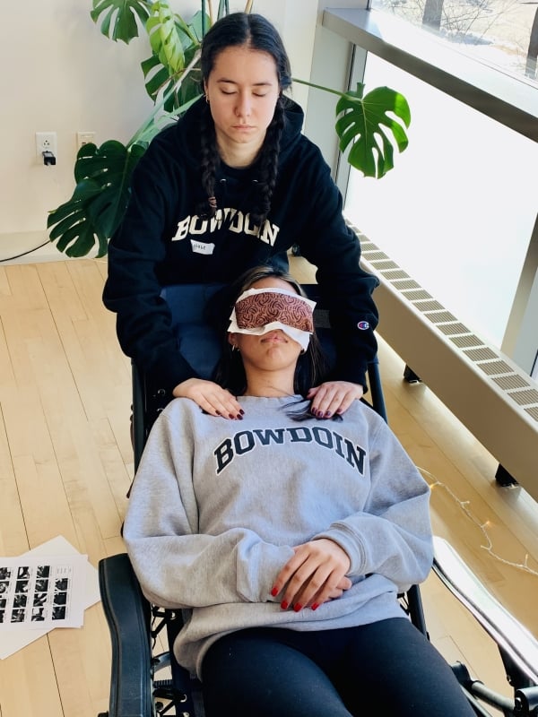 A Bowdoin student practices Reiki on a peer.